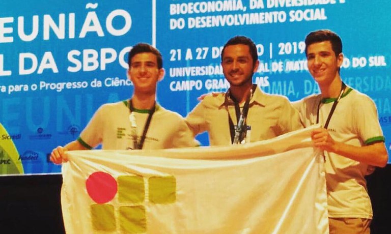 Orientador e estudantes em feira científica